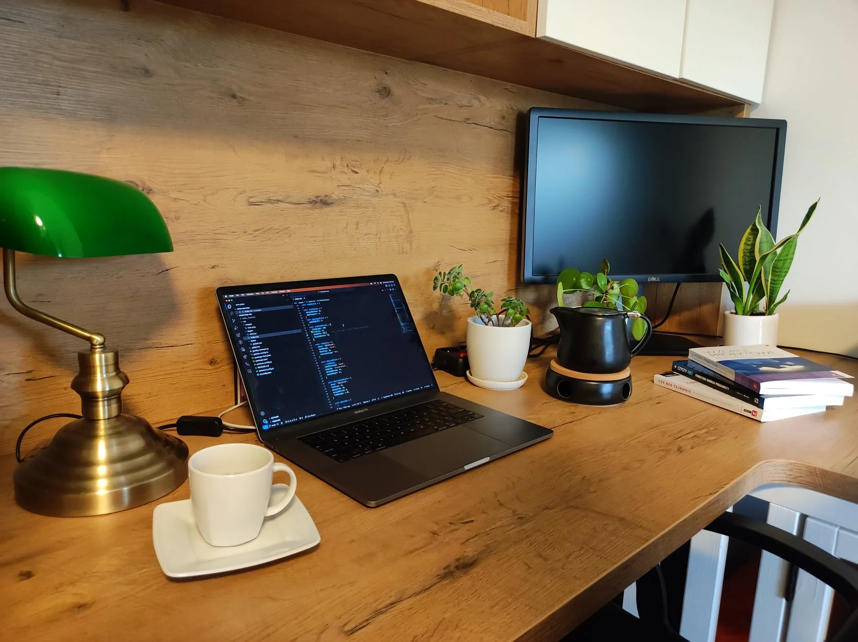 Brown desk with a laptop, coffee, and a plant